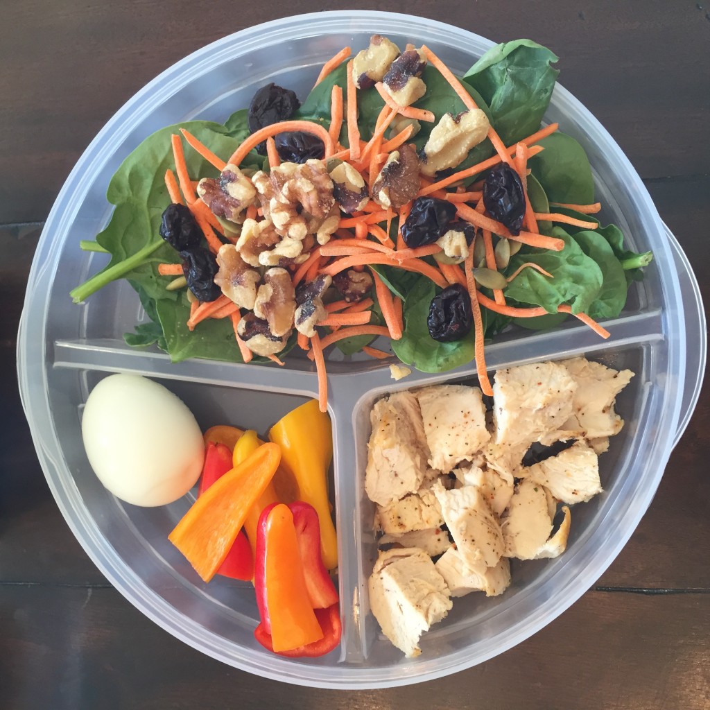 Fresh spinach, shredded carrots, dried cherries, pumpkin seeds, walnuts, chicken breast a boiled egg and fresh bell peppers